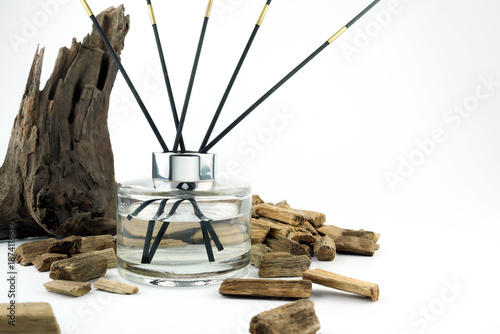 luxury aroma scented reed diffuser glass bottle with black sticks on white table with oud wood or agarwood in nice living room which can create cozy relax aroma ambient scent in from room freshener