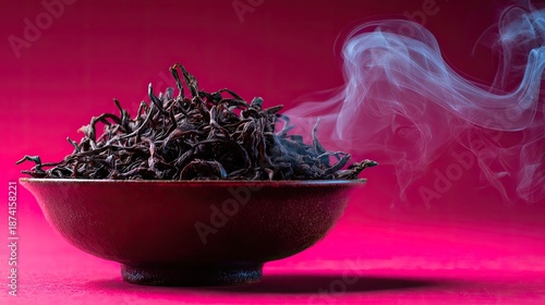 Dark Tea Leaves Steaming in Bowl on Pink Background
