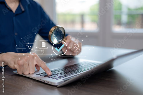 Business verification and data review concept with magnifying glass and check mark on laptop. Digital search, audit, compliance, security validation, and quality control for online systems and modern 