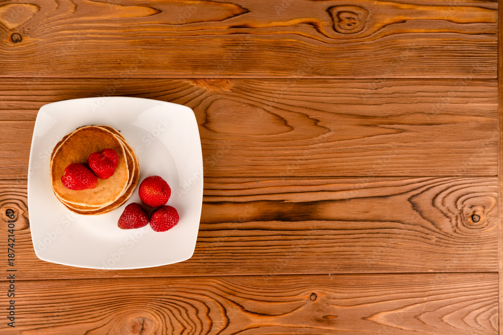 Obraz premium Pancakes with berries on a white plate on the table