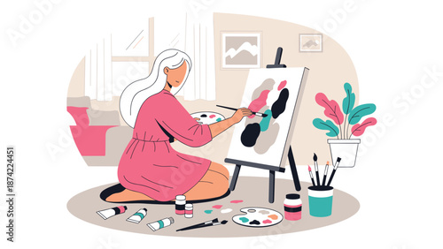 Woman painting at home on canvas in a cozy living room setting, featuring modern art supplies