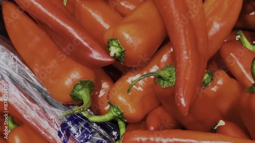 Crates filled with sweet red peppers in a supermarket sales area. 