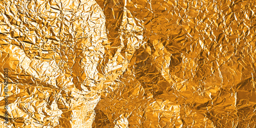 Gold foil texture with glossy crumpled surface - golden metallic background with wrinkled paper grain pattern. Shiny bronze material with rough folds and luxury sheen for premium elegant design.