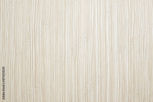 A close-up view of a textured, cream-colored surface with vertical, flowing lines