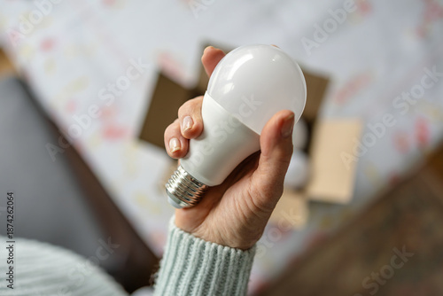 Tableau sur toile Senior woman's hands installing eco light bulb in her home