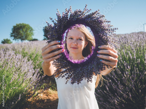 Woman hands with colorful manicure holding lavender wreath
