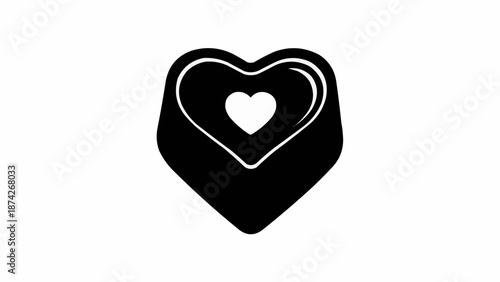 Black heart shape chocolate candy with white outline and inner heart.