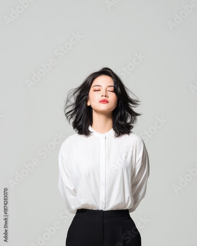Elegant woman with black hair wearing white shirt and black pants