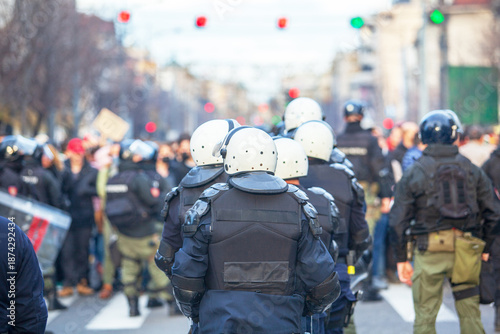 Riot police line in winter city street protest, crowd control, civil unrest and public demonstration security. Police state concept.