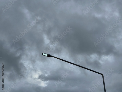 Wallpaper Mural Street light pole illuminated against cloudy evening sky with moody urban atmosphere and minimal composition Torontodigital.ca