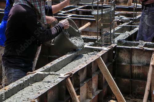 Construction Workers Pouring Concrete into Beam Formwork.
