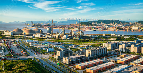 Foto Vibrant industrial port and factory complex located along the coast under a clear blue sky during the day