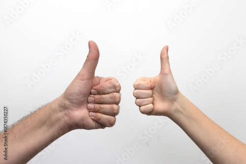 
Dłonie ojca i dziecka pokazujące kciuki w górę. Zdjęcie na białym tle.