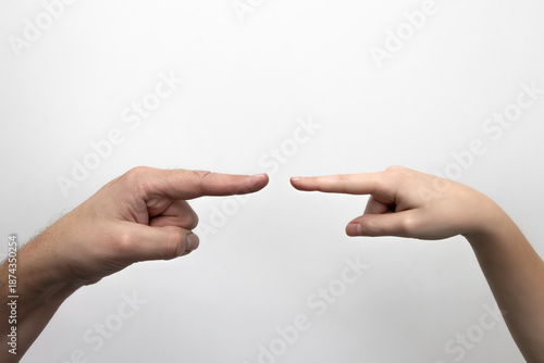Dłonie ojca i dziecka  ze wskazującymi palcami. Zdjęcie na białym tle.