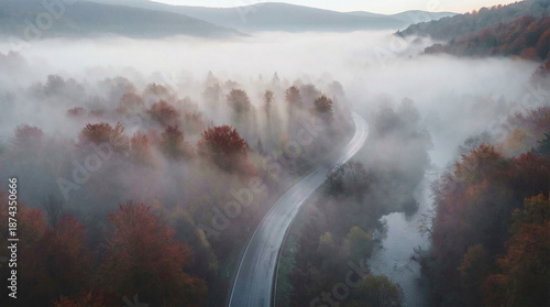 Aerial View of Misty Autumn Forest Road Winding Through Foggy Mountains with Colorful Fall Foliage at Dawn