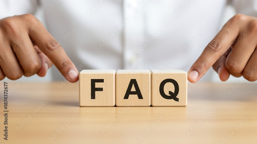 Naklejka premium Hands pointing at wooden blocks spelling FAQ on a wooden table, representing frequently asked questions and information.