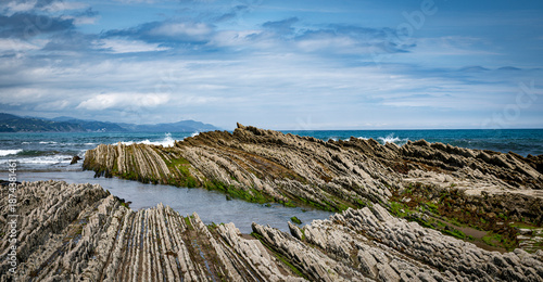 itzurun beach or zumaia beach in spain with blue sky