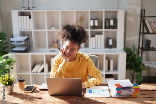 Quadro em tela African American woman concentrating and thinking while working on her laptop co