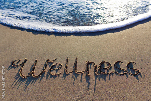 Wellness handwritten on the caribbean sand.