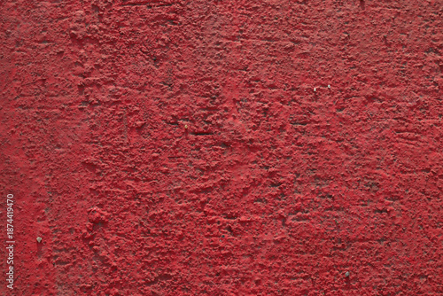 Wall of concrete piles is painted with red paint.