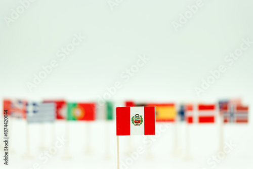Collection of small flags arranged on a table showing different countries with focus on Peru