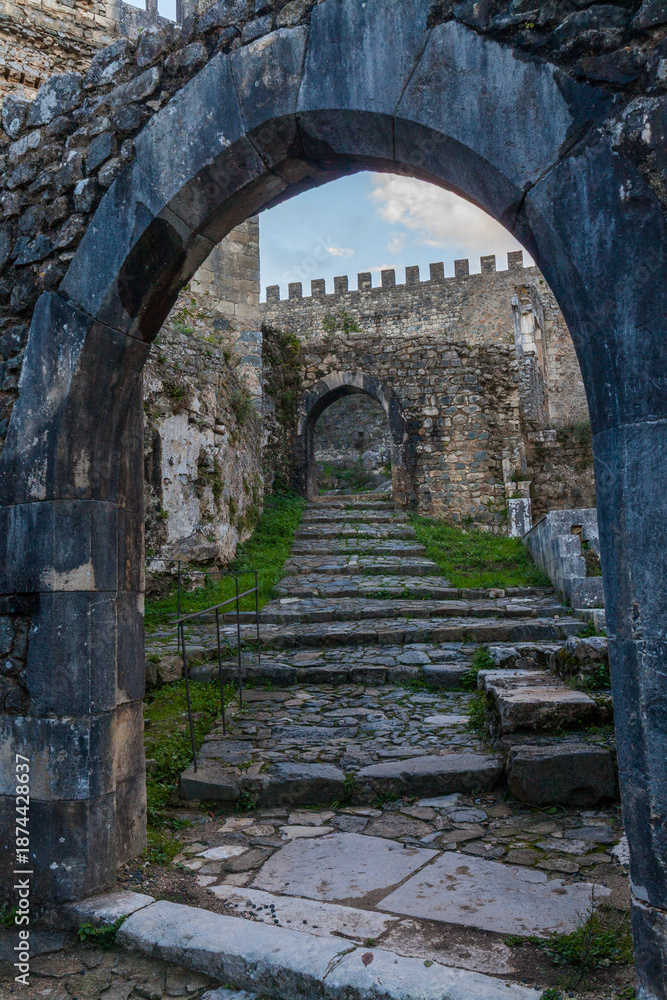 Obraz premium A low-angle view through a weathered stone archway