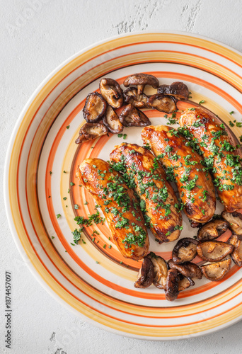 Glazed chicken sausages with herbs and mushrooms on decorative plate studio food