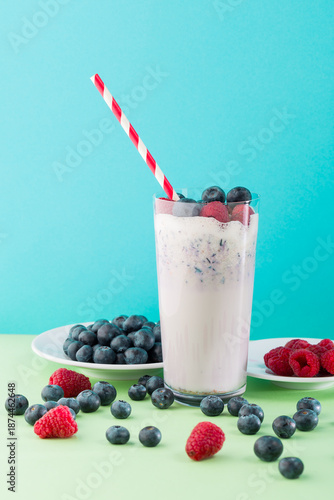 Fruit smoothie with berries served in a glass on a table with fresh raspberries and blueberries