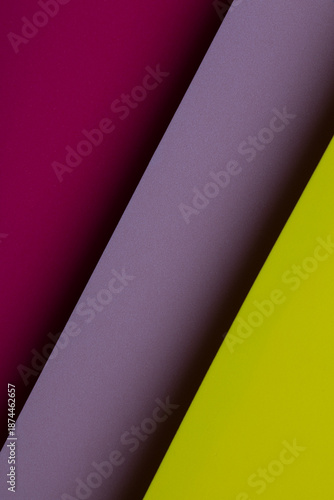 Bright colors of paper arranged at an angle on a flat surface in a creative workspace during daytime hours