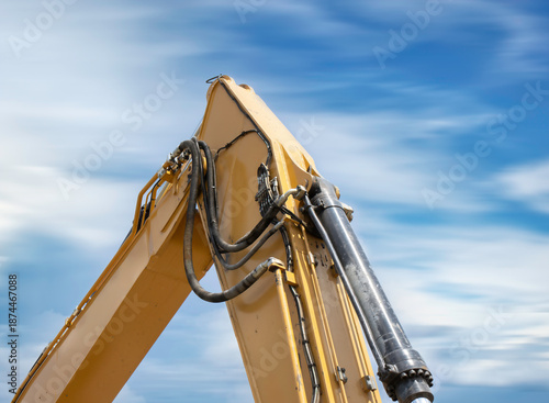 Yellow excavator hydraulic bucket arm, sky and clouds background, nobody