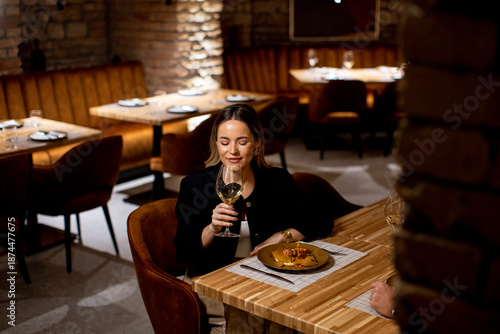 Woman enjoys wine and pasta...