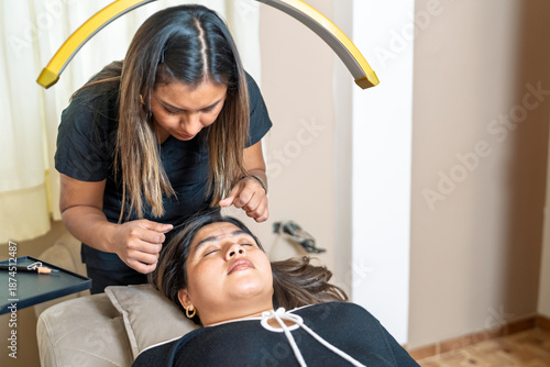 Lash artist applying eyelash extensions to client