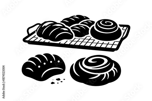 Black and white bakery treats on cooling rack: buns and rolls