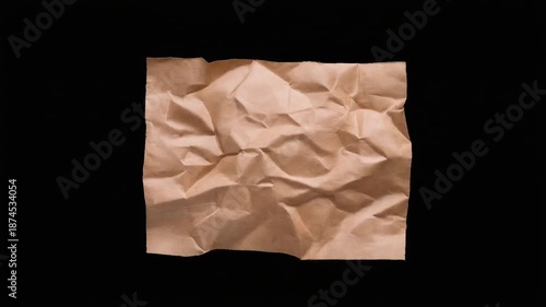Crumpled brown recycled paper ball unfolding with textured creases and soft shadowed contrast step by step into flat sheet with