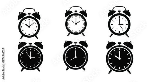 A collection of classic black alarm clocks displaying different times