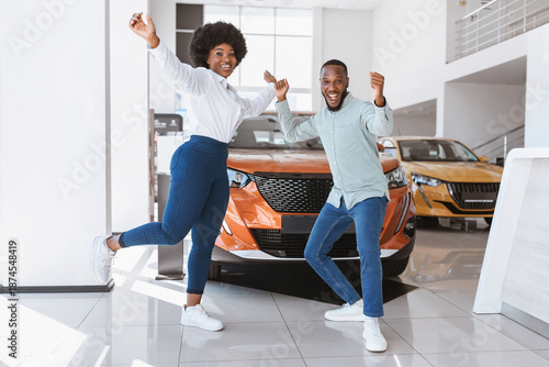 Wallpaper Mural Young black couple cheering and dancing, gesturing YES, celebrating purchase of new car at auto dealership. Full length of Afro family buying automobile, feeling excited at showroom store Torontodigital.ca