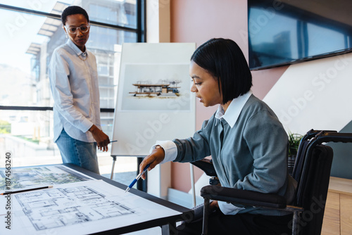 Fotografía Two women discussing architectural plans in a modern office setting