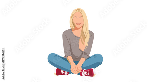 Smiling young woman with blonde hair sits cross-legged on the floor wearing a grey sweater and blue jeans on a simple white background.