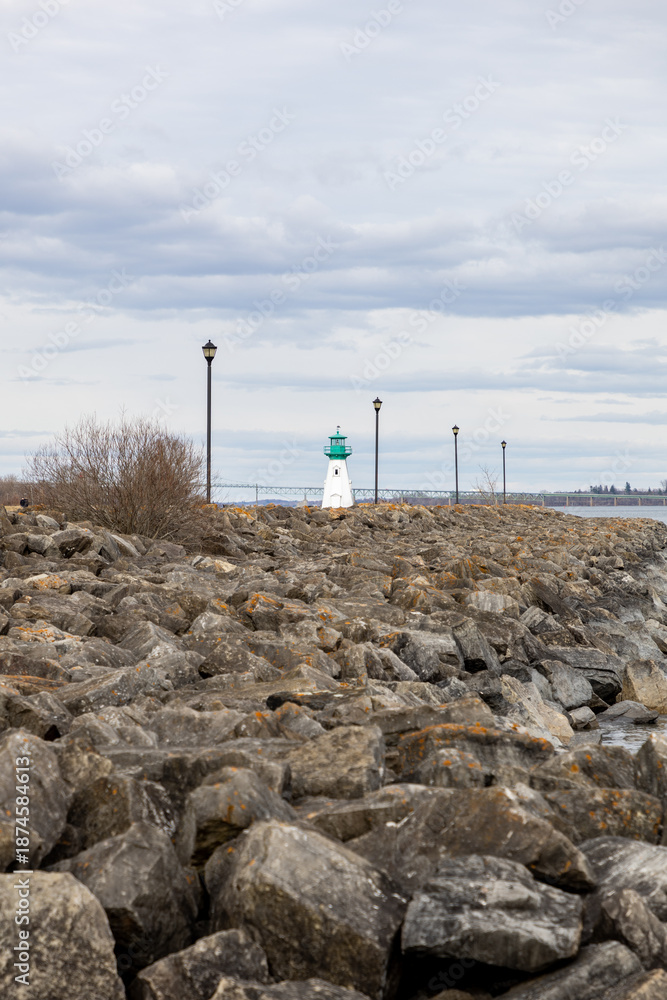 Fototapeta premium Prescott rocky waterfront and lighthouse on St. Lawrence River in Ontario, Canada. Small lighthouse.