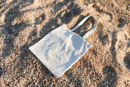 White cotton or mesh bag on beach sand background