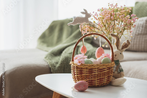 Photos Easter Basket with Ester Eggs,  Plush Bunny and Spring Decor on White Table into
