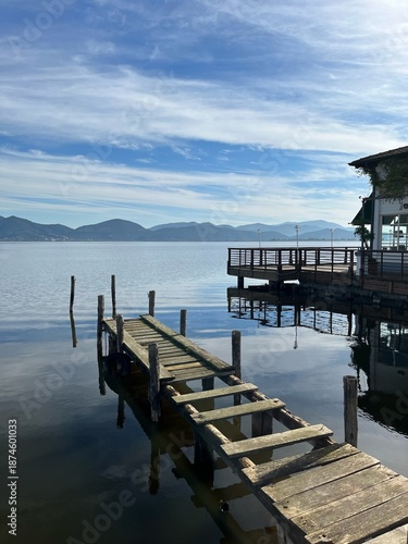 A beautiful view of a lake, with a wooden bridge.