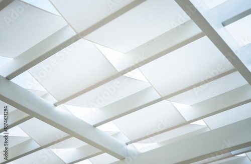 White modern tensile shade structure creating a geometric abstract pattern, forming a contemporary architectural ceiling or background with clean lines and soft diffused light