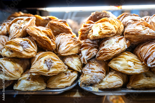 Assorted Neapolitan pastries with chocolate and cream filling in a bakery.