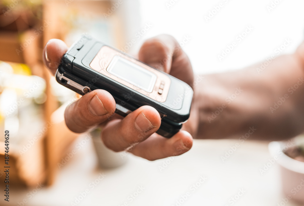 Fototapeta premium Man holding a feature phone for digital detox.