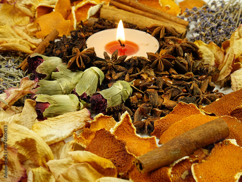 Dried herbs, flowers, spice, orange peel and scented candle, side view, background. Ingredients for air freshening and relaxation.
 