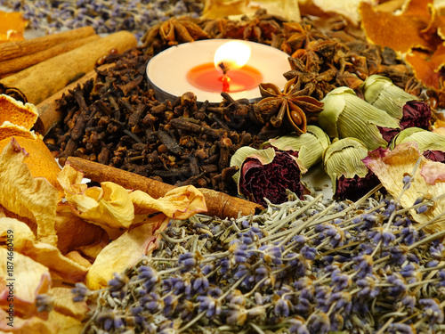 Dried herbs, flowers, spice, orange peel and scented candle, side view, background. Ingredients for air freshening and relaxation.
 