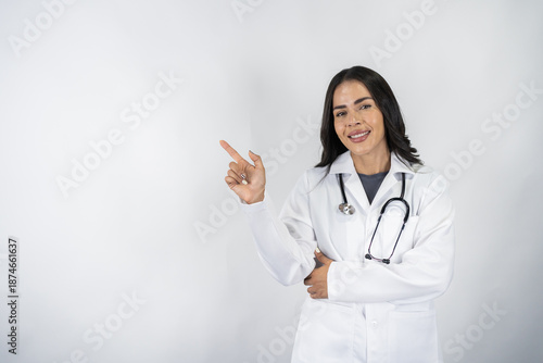 Smiling female doctor pointing with her hand with copyspace
