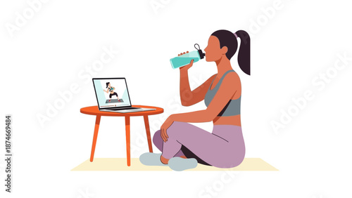 Woman drinking water while following online workout on laptop at home
