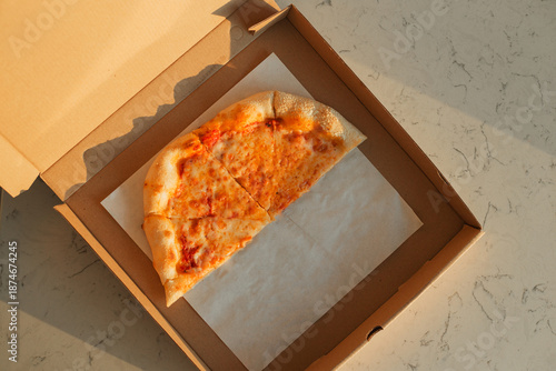 A half eaten take away pizza margherita in box. Classic Italian pizza with mozzarella cheese and tomato sauce ready to eat.